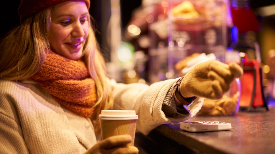 Weihnachtsmarkt-Besucherin beim Bezahlen: Flanksteak, Brötchen mit Trüffel (für 15 €)
