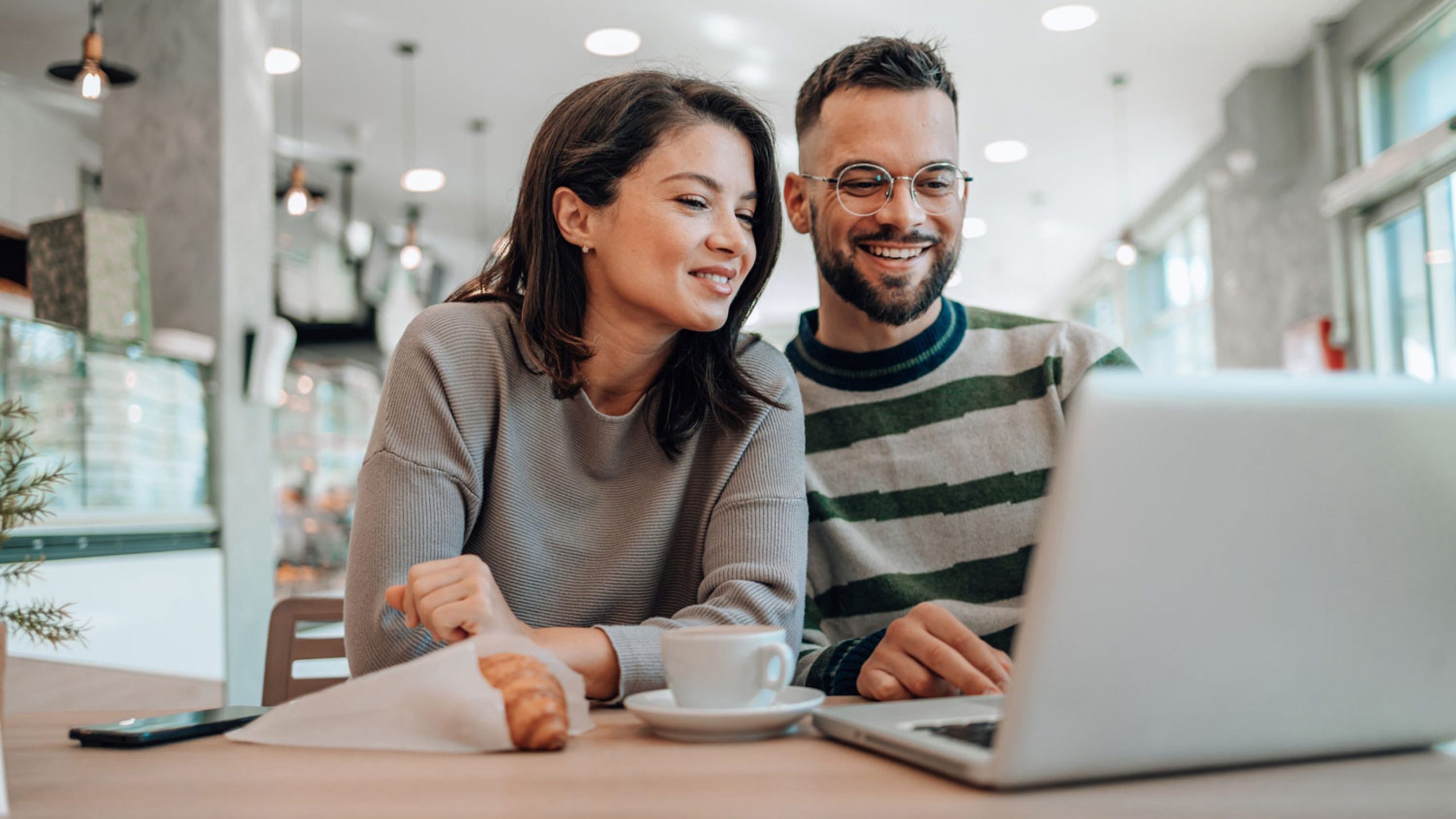 A couple planning finances in a modern café