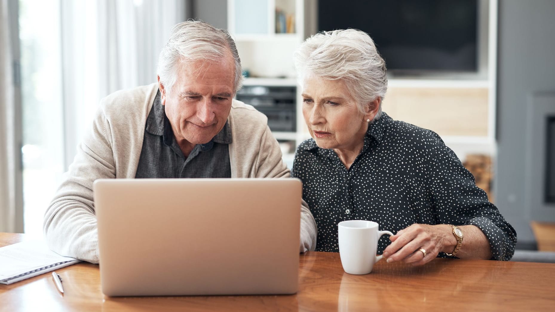 A couple at home in front of a laptop while working on a tax return