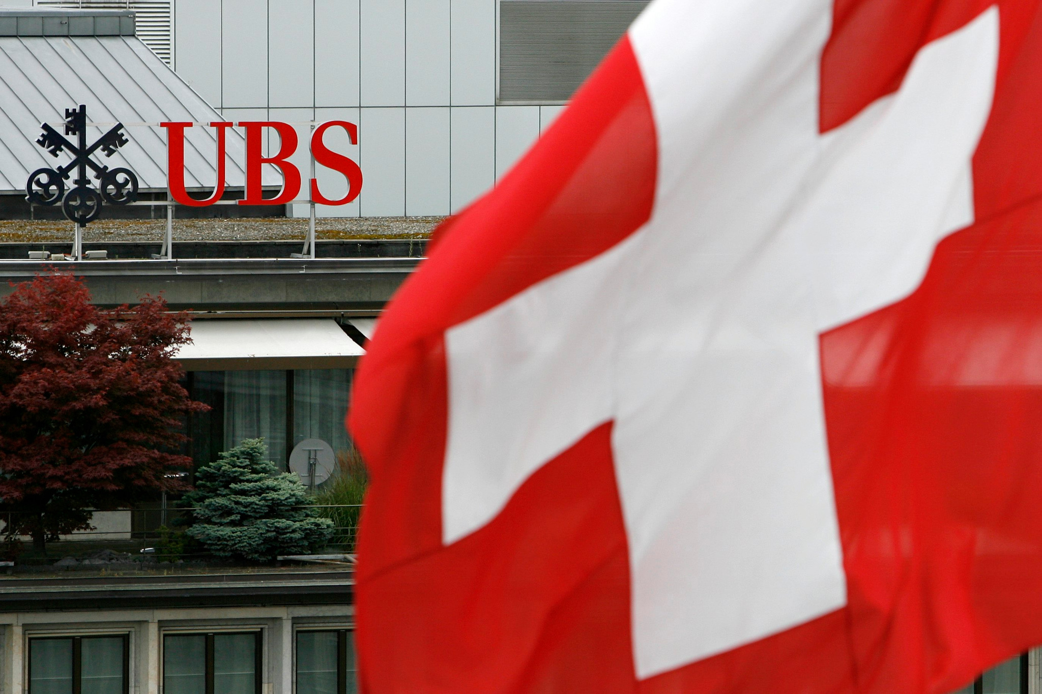 UBS Logo am Paradeplatz in Zürich mit Schweizer Flagge im Vordergrund