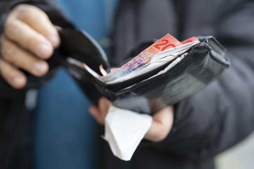 Person handling Swiss banknotes at market