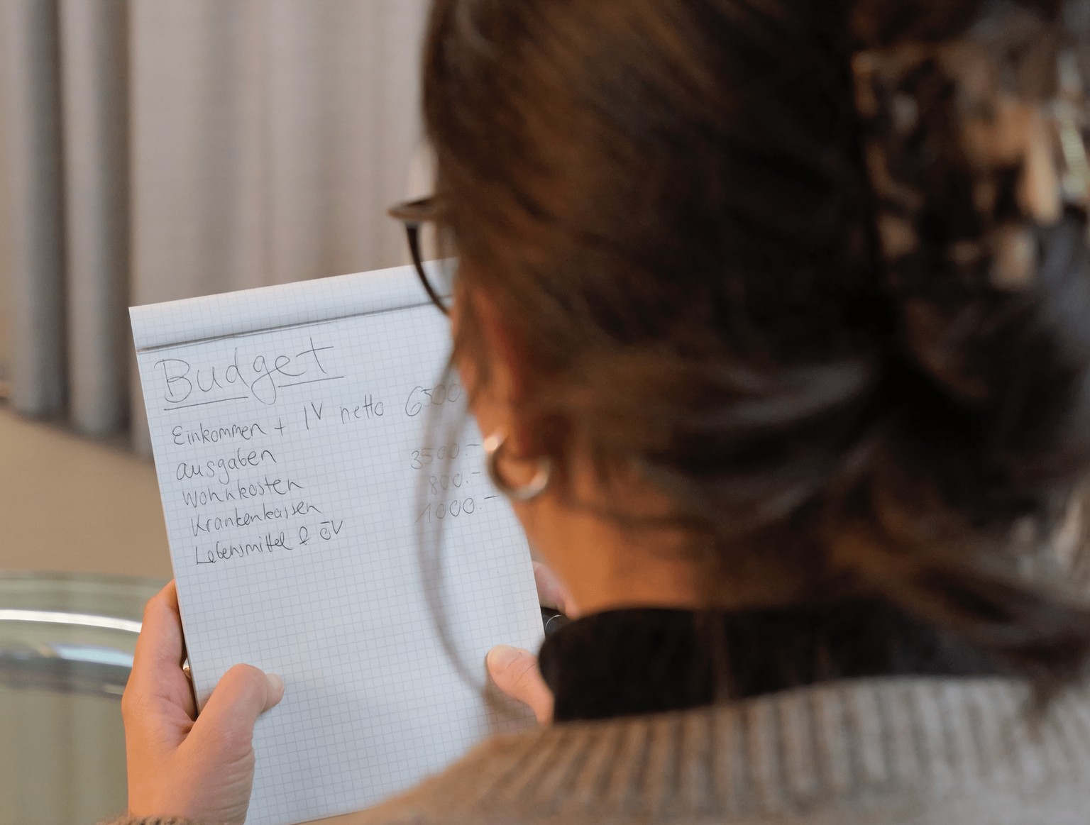Symbolbild: Frau, die ihr Budget mach, aber kein Geld sparen kann.