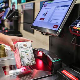 A woman using a self-checkout kiosk