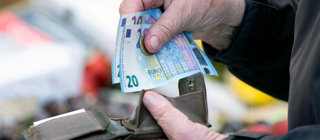 A person with a wallet full of cash