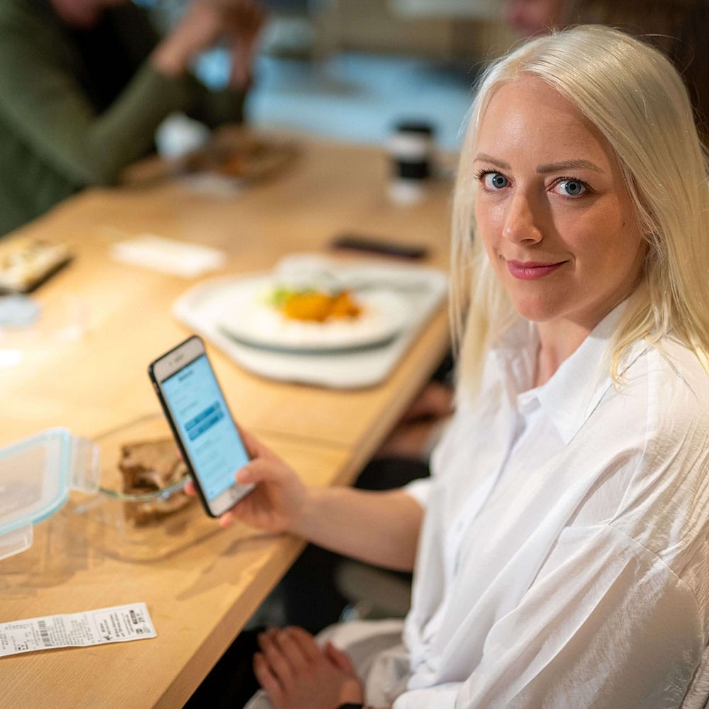 Zufriedene Mitarbeiterin genießt ihren Essenszuschuss vom Arbeitgeber.