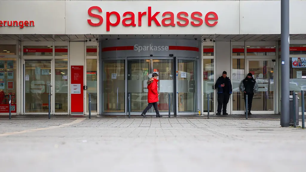 Security workers stand in front of the Sparkasse Gelsenkirchen which is still closed in the archive image