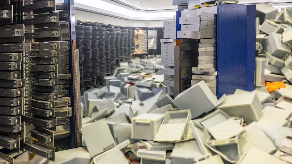 Opened safe deposit boxes, empty boxes and documents lie in the vault room of the Sparkasse