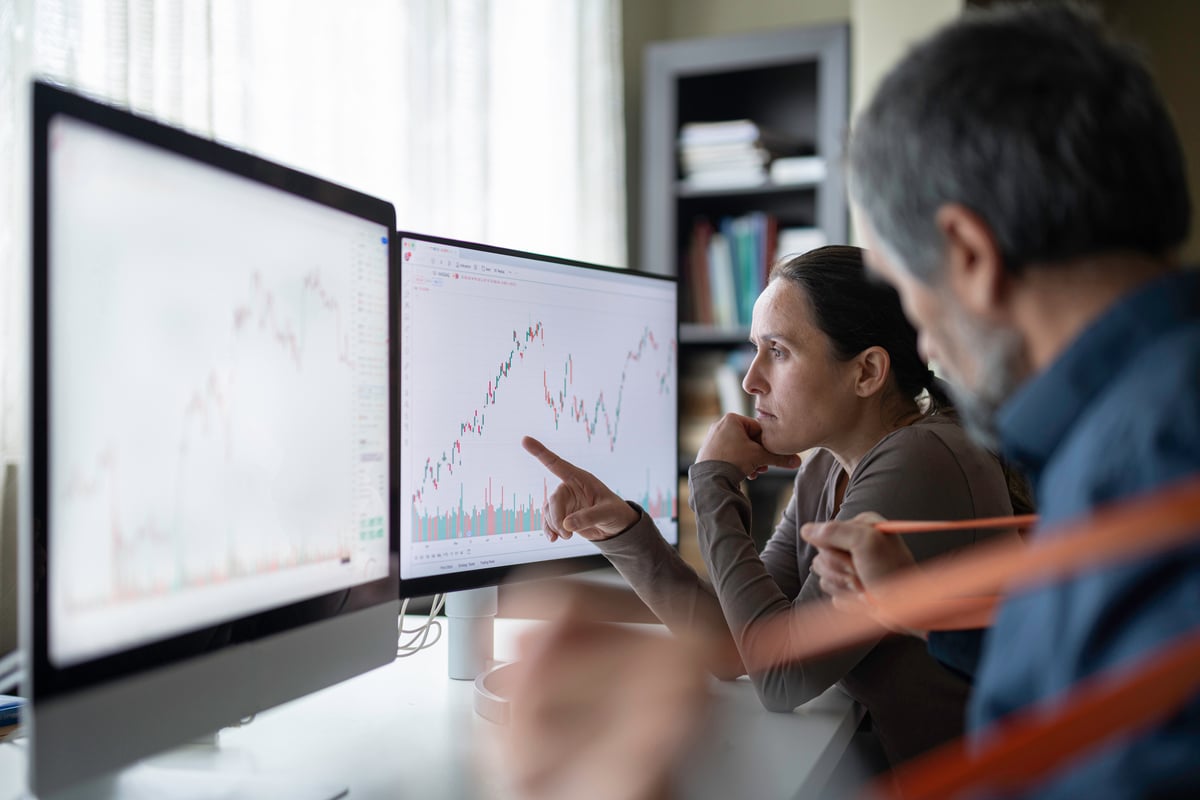 Analysts studying stock charts on desktop monitors