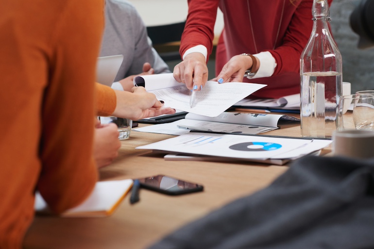 Three people discussing interest rates at a table