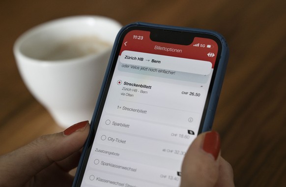 A woman comparing route tickets and saver tickets via SBB app on her smartphone for the Zurich HB - Bern route, photographed on Tuesday, July 2, 2024 in Zurich.