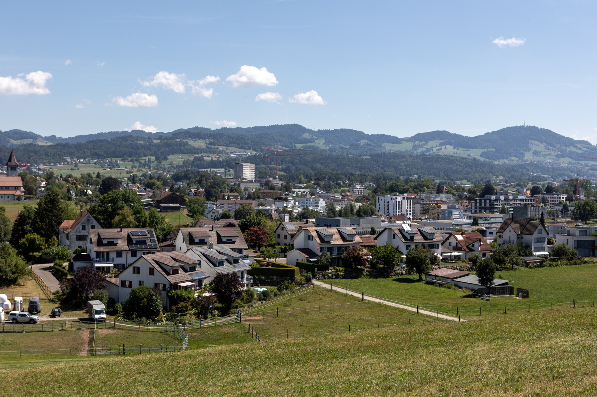 Mehrere Einfamilienhäuser in einer ländlichen Gegend mit Hügeln im Hintergrund