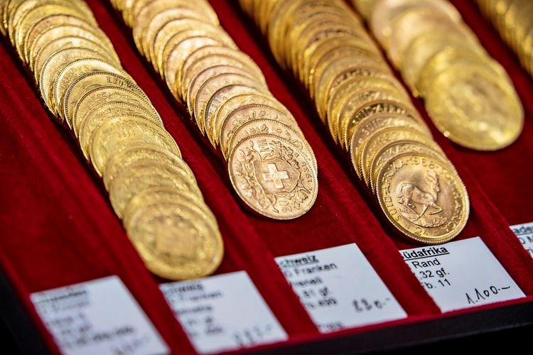 Gold coins in a red box, including Swiss 20-franc coins