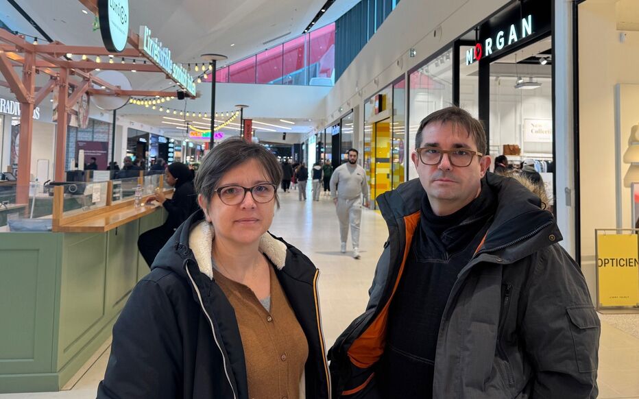 Magali and Emmanuel, both 50, in Cergy shopping center discussing their financial situation