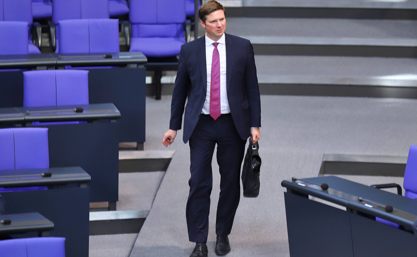 Florian Toncar standing at a podium in the Bundestag wearing a suit