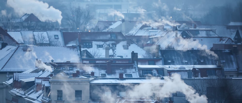 Smoke rising from chimneys on a cold winter morning representing landlord utility risks