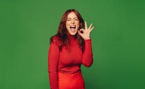 Happy woman making OK sign