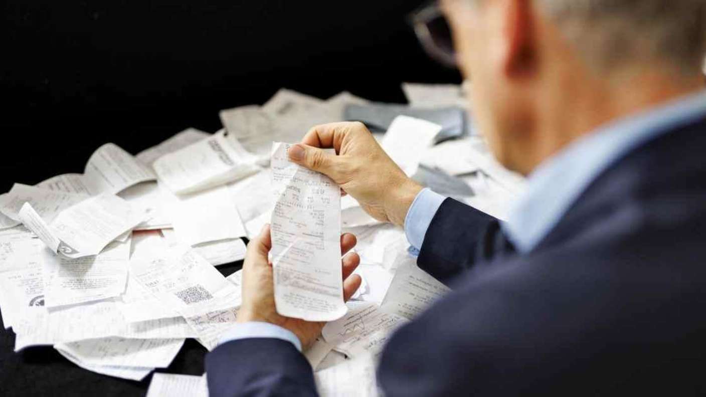 Steuern: Ein Mann hält Belege in der Hand