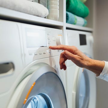 vrouwenhand klikt op knopje wasmachine